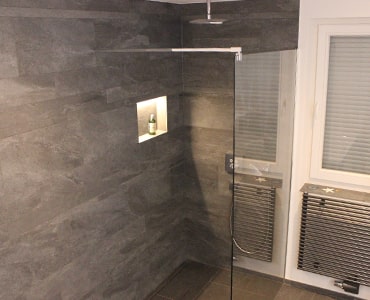 Detailansicht eines Duschbereichs mit präziser Mosaikverlegung und Nische.