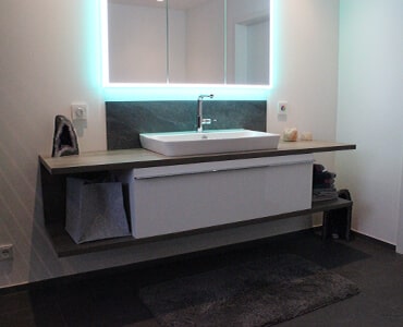 Designer-Waschbecken mit passendem Fliesenmosaik, Beispiel für individuelle Badgestaltung.