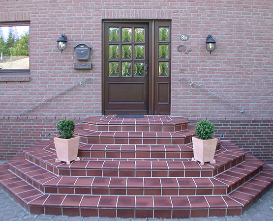 Eingangspodest mit hochwertiger Plattenverlegung, robust und einladend gestaltet.